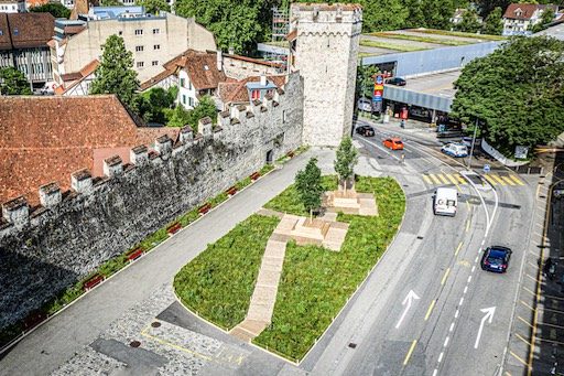 Luftaufnahme des Platzes bei der Stadtmauer mit Wiese, Wegen und Sitzbänken